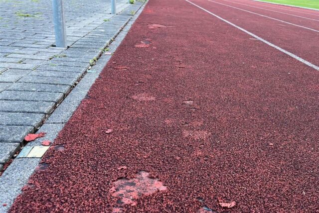 Löchrige Tartanbahn auf dem Sportplatz Dahl