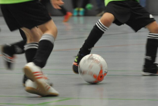 G-Jugendfußballer laufen einem Ball hinterher.
