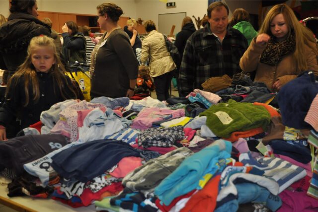 Menschen durchstöbern Kinderkleidung