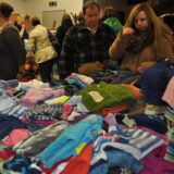 Menschen durchstöbern Kinderkleidung