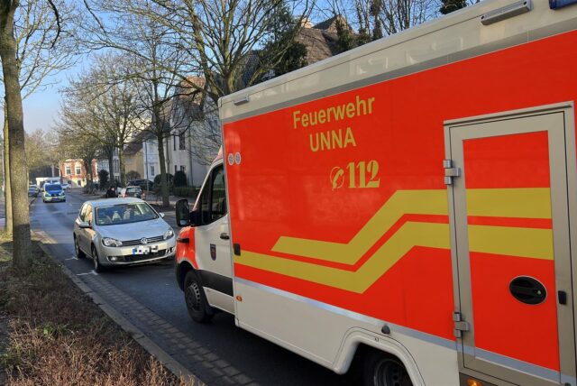 Nach einem Unfall am Freitag (17.1.) steht auf der Iserlohner Straße in Unna ein Rettungswagen vor einem Auto. Im Hintergrund sperrt ein Polizeiwagen die Straße.