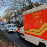 Nach einem Unfall am Freitag (17.1.) steht auf der Iserlohner Straße in Unna ein Rettungswagen vor einem Auto. Im Hintergrund sperrt ein Polizeiwagen die Straße.