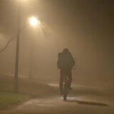 Ein Radfahrer fährt bei dichtem Nebel durch einen Park.