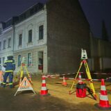 Kräfte des Technischen Hilfswerks (THW) sind mit einem Lasermessgerät vor einem mutmaßlich einsturzgefährdeten Haus in Bergisch Gladbach im Einsatz.