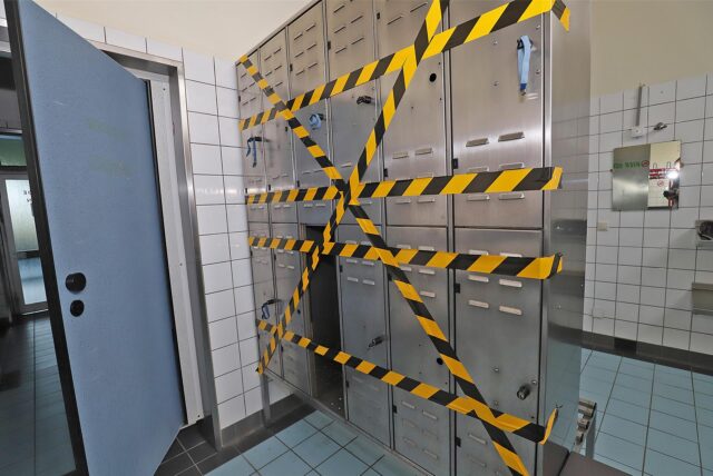 Im Hellwegschwimmbad in Massen sind Spinde einer Umkleide mit schwarz-gelbem Signalklebeband versperrt.