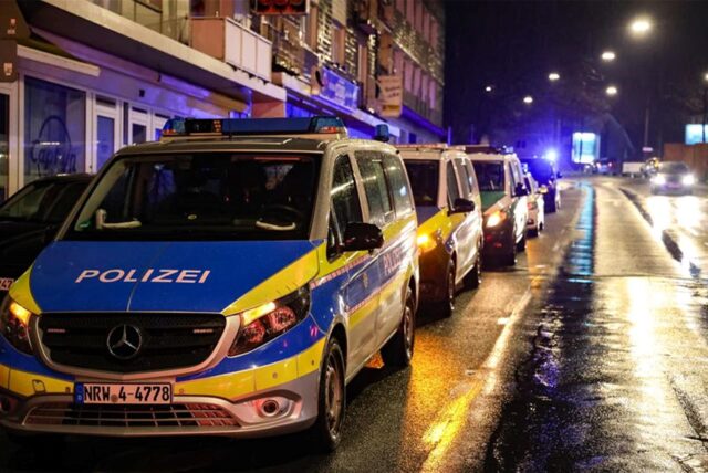 Polizeiautos stehen auf einer Straße.