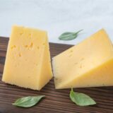 Zwei Stücke Käse auf einem Brett.