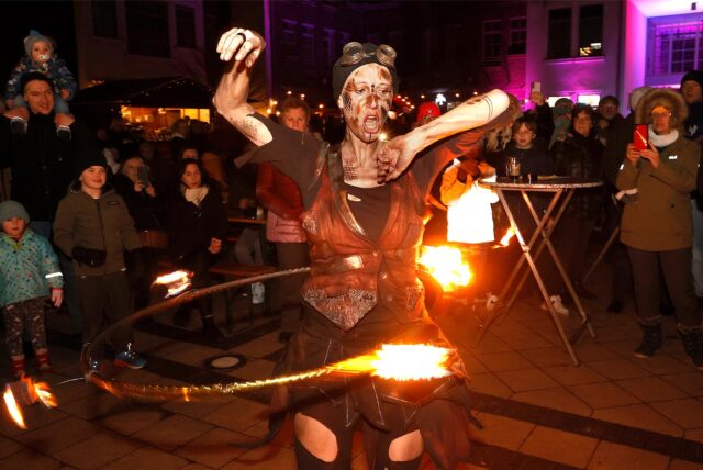 Eine Künstlerin macht Hula Hoop mit einem brennenden Reifen.