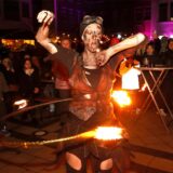 Eine Künstlerin macht Hula Hoop mit einem brennenden Reifen.