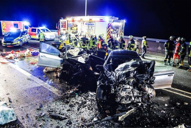 Zwei schwer beschädigte Autos stehen nach einem Unfall in Hagen-Eilpe auf der Straße. Die Feuerwehr ist im Einsatz mit einem Rettungswagen.