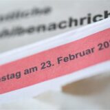 Eine geöffnete amtliche Wahlbenachrichtigung zur Wahl zum deutschen Bundestag am 23. Februar 2025 liegt auf einem Tisch.