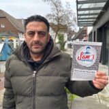Ein Mann hält einen Werbezettel in die Kamera