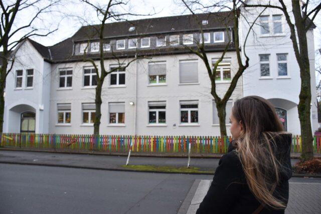 Die Mutter, deren Sohn gemobbt wird, weil er kein Muslim ist, steht vor der Schopenhauer-Grundschule in Dortmund.