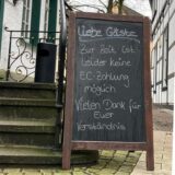 Im linken Teil der Montag ist eine Kreidetafel mit dem Hinweis „Liebe Gäste: Zur Zeit ist leider keine EC-Zahlung möglich. Vielen Dank für Euer Verständnis“ zu sehen. Im rechten Teil ist der Betreiber des Agethen Aleks Dymek für seinem Gasthaus in Unna zu sehen.