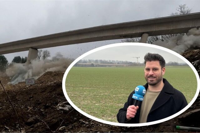 HA-Reporter Stefan Schier mit einer Live-Berichterstattung über die Sprengung der Liedbachtalbrücke südlich des Autobahnkreuzes Dortmund/Unna. Im Hintergrund ist der Zeitpunkt der Explosion der Brückenpfeiler der Liedbachtalbrücke zu sehen.