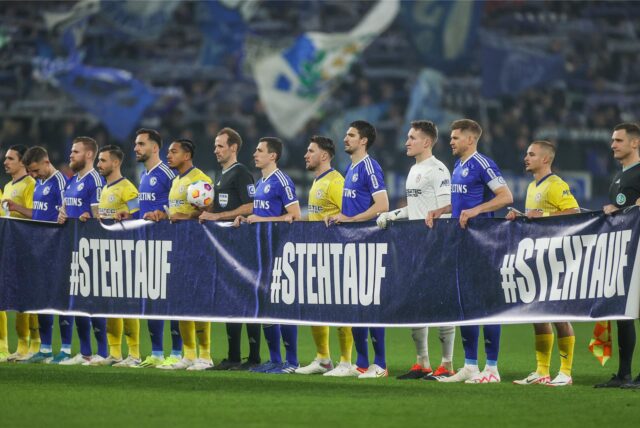 03.02.2024, Fussball, 2. Bundesliga, 18. Spieltag, Saison 2023/2024, FC Schalke 04 – Eintracht Braunschweig, Beide Mannschaften halten ein Spruchband für die Aktion #StehtAuf