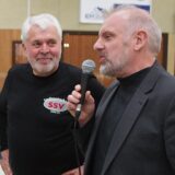 Dirk Wigant spricht in ein Mikrofon, Volker Königs schaut ihn an.