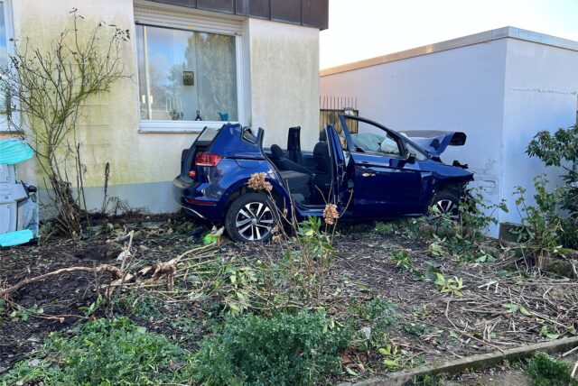 Ein völlig demoliertes blaues Auto mit abgeschnittenem Dach steht in dem Vorgarten eines Hauses im Akazienweg in Unna
