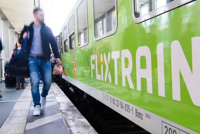Jemand geht an einem Flixtrain entlang.
