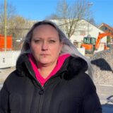 Dina Stöckner (43) schaut mit einem neutralen Blick in die Kamera. Im Hintergrund die Baustelle am Südfeld in der Unschärfe.