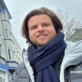 Unnas Klimaschutzmanager Thomas Heer steht vor einer begrünten Fassade in der Innenstadt.