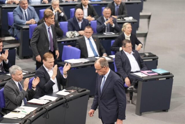 Friedrich Merz, CDU-Bundesvorsitzender und CDU/CSU-Fraktionsvorsitzender im Bundestag, läuft an der AfD-Fraktion (r) vorbei, die nach der Bekanntgabe der Ergebnisse der Abstimmung für eine Verschärfung der Migrationspolitik reagiert
