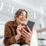 Junge Frau surft mit ihrem Smartphone im Internet