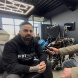 Siya Shokohi, Inhaber von WBT Customs in Holzwickede im Interview mit HA-Reporter Stefan Schier. Shokohi ist an den Händen und am Hals tätowiert. Er trägt einen schwarzen Pullover. Der HA-Reporter trägt einen hellen Mantel und eine Brille.