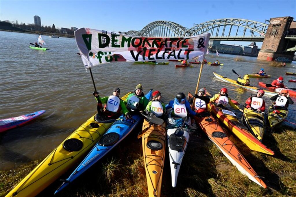 Premiere in Köln: Auf dem Rhein demonstrieren Wassersportler für Demokratie und Vielfalt. Premiere in Köln: Auf dem Rhein demonstrieren Wassersportler für Demokratie und Vielfalt.