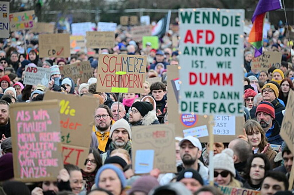 Menschen halten während einer Demonstration in Berlin unter dem Motto „Aufstand der Anständigen - Demo für die Brandmauer“ Schilder hoch, auf denen unter anderem „Schmerz verhindern“ steht. Menschen halten während einer Demonstration in Berlin unter dem Motto „Aufstand der Anständigen - Demo für die Brandmauer“ Schilder hoch, auf denen unter anderem „Schmerz verhindern“ steht.