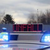 Ein Schild auf einem Polizeiauto warnt vor einem Unfall.