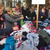 Frauen stöbern in einem Kleiderhaufen.
