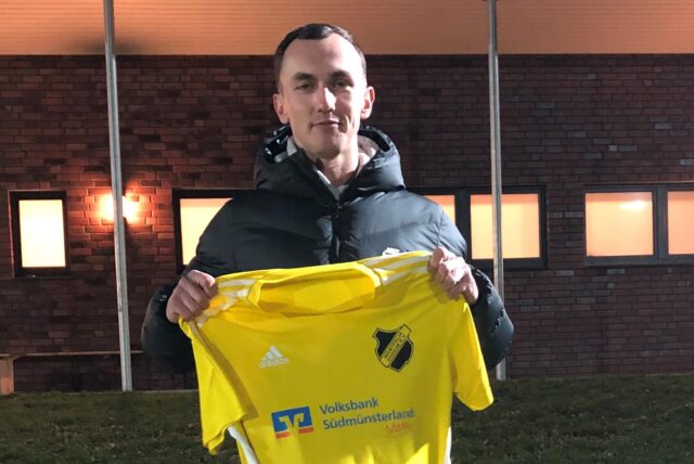 Dustin Nowak hält ein Trikot von Westfalia Vinnum in die Kamera.
