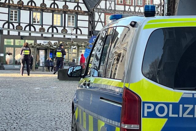 Ein Mercedes-Kleinbus der Unnaer Polizei steht am oberen Ende der Wasserstraße, während seine Besatzung etwas eiter im Hintergrund vor der Fachwerkkulisse des Alten Marktes Wache hält.