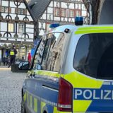 Ein Mercedes-Kleinbus der Unnaer Polizei steht am oberen Ende der Wasserstraße, während seine Besatzung etwas eiter im Hintergrund vor der Fachwerkkulisse des Alten Marktes Wache hält.