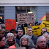 Bei einer Demonstration in Unna halten Menschen verschiedene Plakate hoch