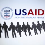 Das Logo der US-Entwicklungsbehörde, United States Agency for International Development (USAID), ist hinter einer Kette von ausgeschnittenen Papierfiguren zu sehen.