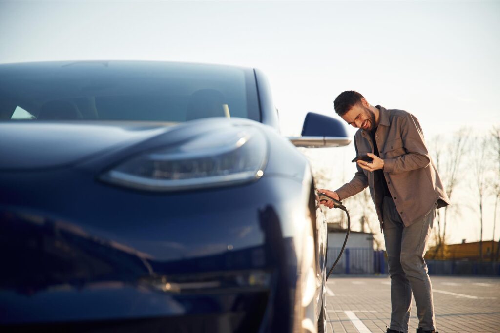 Mann lädt Elektroauto Mann lädt Elektroauto