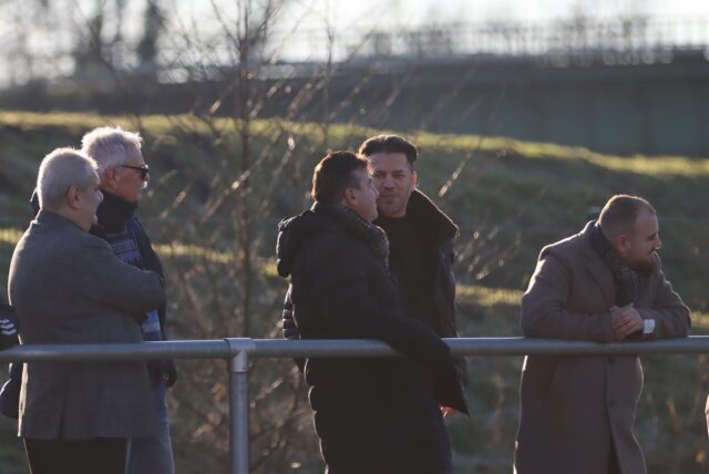 Imdat Acar (v.l.), Arno Franke und Bayram Ulusoy sowie Tuna Kayabasi (r.) gucken auf ein Fußballfeld.