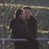 Imdat Acar (v.l.), Arno Franke und Bayram Ulusoy sowie Tuna Kayabasi (r.) gucken auf ein Fußballfeld.