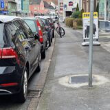 In einem Bürgersteig in Unna ist ein frischer Asphaltflicken. Daneben parken Autos auf der Straße