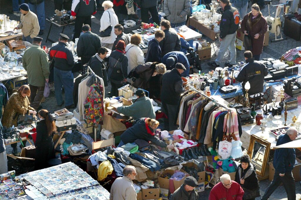 Viele Menschen in Winterjacken durchstöbern die Stände auf einem Trödelmarkt. Viele Menschen in Winterjacken durchstöbern die Stände auf einem Trödelmarkt.