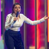 Comedian Tahnee bei einem Auftritt mit Mikrofon in der Hand.