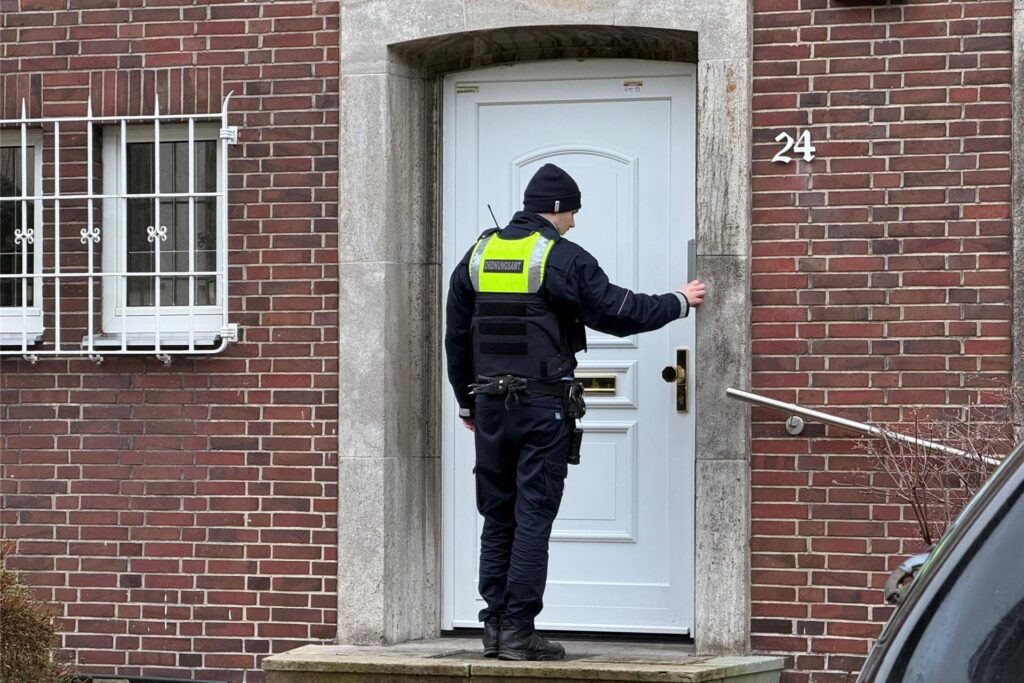 Ein Ordnungsamtsmitarbeiter klingelt im Evakuierungsbereich in Dortmund an die Tür eines Wohnhauses.
