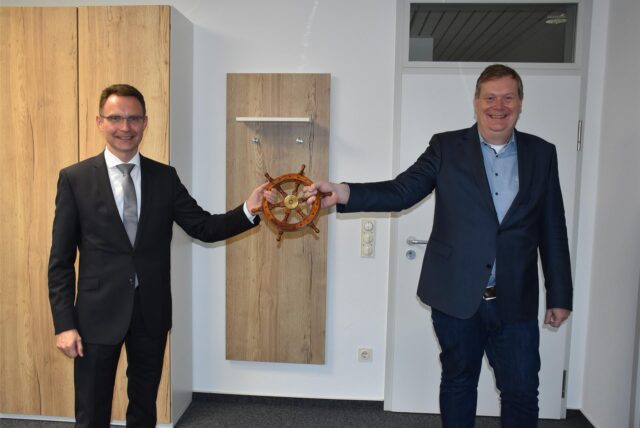 Dr. Bert Risthaus (links) übergibt symbolisch ein Steuerrad an Thomas Stohldreier.