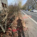 Auf der Unnaer Straße in Fröndenberg-Strickherdicke sind Unfall-Markierungen der Polizei aufgebracht. Am linken Fahrbahnrand ist ein zerstörter Holzzaun zu sehen.