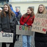 Frauen halten Plakate in die Kamera, auf denen sie sich klar gegen die AfD und für Vielfalt positionieren.