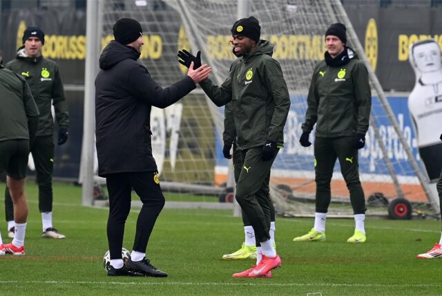 Carney Chukwuemeka klatscht mit einem BVB-Mitarbeiter ab.