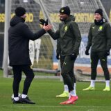 Carney Chukwuemeka klatscht mit einem BVB-Mitarbeiter ab.
