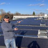 Mike Morlock (Firma Hellgrün Solar) zeigt die neue Photovoltaikanlage auf dem Dach des Katasteramts in Unna-Königsborn.